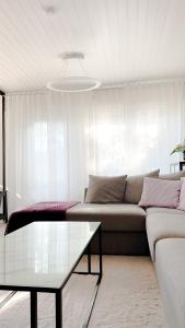 a living room with a couch and a table at Rubin Apartment - moderni huoneisto lähellä keskustaa in Kajaani +16 photos
