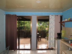 a kitchen with a door open to a patio at Rose House Manuel Antonio in Quepos