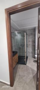 a bathroom with a shower and a glass door at Appartement neuf Monte Cabo in Cabo Negro