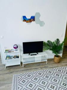 ヒルデスハイムにあるGrothes City Apartment am Rathausの白い壁のリビングルーム(テレビ付)