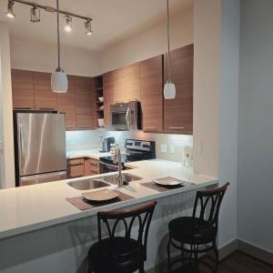 a kitchen with a sink and two bar stools at Midtown Downtown Breeze in Houston