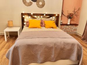 sypialnia z dużym łóżkiem z żółtymi poduszkami w obiekcie TheCozyHouse Novi Sad w Nowym Sadzie