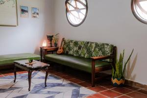 a living room with a green couch and a table at Qué onda! in Ubatuba