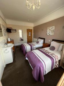 a hotel room with two beds and a sink at The Fernroyd in Blackpool