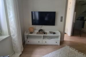 a white cabinet with a flat screen tv on a wall at Ferienwohnung bei Lübeck in Lüdersdorf