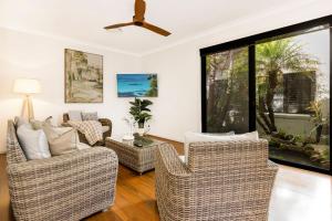 a living room with chairs and a ceiling fan at The Atrium by Experience Jervis Bay in St Georges Basin