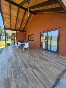 a large wooden deck with a table and chairs on it at Casa en condominio de parcelas in Yumbel +9 photos