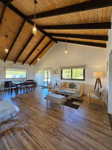 a large living room with wooden ceilings and furniture at Casa en condominio de parcelas in Yumbel
