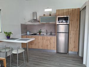 a kitchen with a stainless steel refrigerator and a table at Casita Leos in Agüimes
