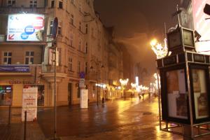 a city street at night with a phone booth at Apartamenty Mickiewicza in Katowice