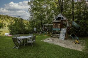 a playground with a slide and a table and chairs at Du Bonheur Lac Pare - Waterfront, Spa & FirePit in Grande Vallee