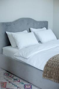 una cama con almohadas blancas encima en Slavutich apartment #2, en Kiev
