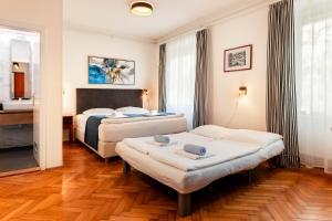 a hotel room with two beds and a bathroom at Penzion Pod Lipo in Ljubljana
