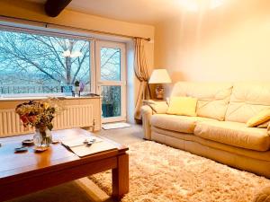 a living room with a couch and a table at Tilly Cottage - overlooking Pendle Hill in Barrowford