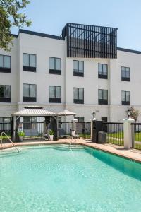 a swimming pool in front of a building at Champions Club and Hotel, Houston Westchase in Houston