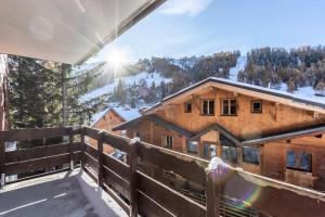 a person standing on the balcony of a log cabin at Résidence Digitale - Résidence DIGITALE N°710 MAE-5201 in La Plagne Tarentaise