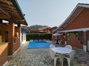 a patio with a table and chairs and a pool at Caminito in Santo Antônio do Pinhal