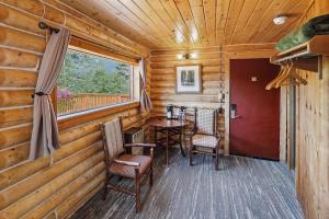 ein Esszimmer mit Tisch und Stühlen und einem Fenster in der Unterkunft Denali Crow's Nest Cabins in McKinley Park