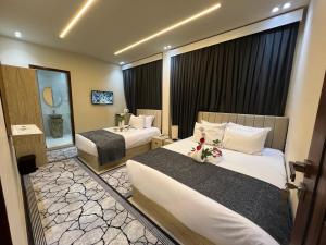 una camera d'albergo con due letti e uno specchio di Golden Scarab Pyramids Hotel a Il Cairo