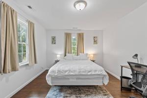 a white bedroom with a bed and two windows at Cozy 1BR 1BA Apartment Near Fort Gregg-Adams in Hopewell