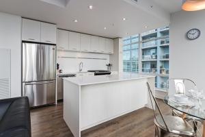 eine Küche mit weißen Schränken und einem Edelstahlkühlschrank in der Unterkunft Underwood Executive Suites by Corporate Stays in Calgary