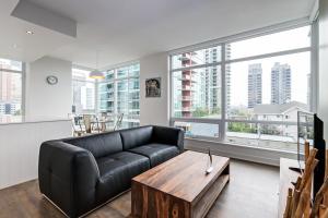 ein Wohnzimmer mit einer schwarzen Ledercouch und einem Tisch in der Unterkunft Underwood Executive Suites by Corporate Stays in Calgary