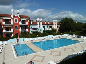 una gran piscina con sillas y un edificio en Le Briccole, en Cavallino-Treporti