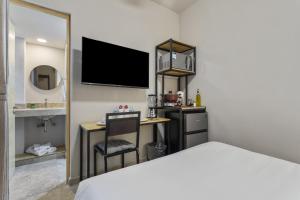 a bedroom with a bed and a desk with a television at Universidad by Homirent in Querétaro