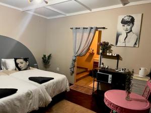 Un dormitorio con una cama y una mesa y una ventana. en Casa De Montague, en Noordheuwel