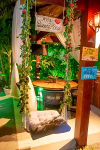 a patio with a table and chairs and a sign at Pousada do Bispo in Cabo Frio