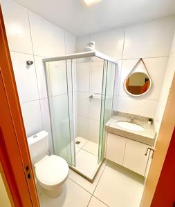 a bathroom with a toilet and a glass shower at Imóvel Novo, 4 Quartos, Ar Condicionado em todos ambientes - Cond. Fechado - Guarajuba-BA in Camaçari
