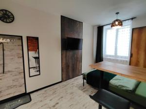 a room with a wooden table and a desk at Apartamenty Królówka in Bydgoszcz