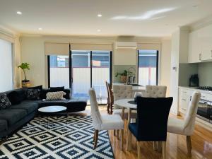 a living room with a couch and a table and chairs at D110 Sweet Melon super stay-fantastic in Braybrook