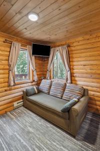 eine Couch in einem Zimmer in einem Blockhaus in der Unterkunft Denali Crow's Nest Cabins in McKinley Park