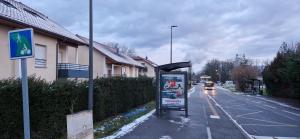 a bus stop sign on the side of a street at Agréable chambre in Prévessin-Moëns