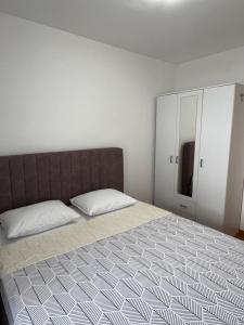 a bedroom with a large bed and a mirror at Apartman 306 in Lukavica