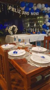 a wooden table with plates and wine glasses on it at Recanto Isla Pousada in Ubatuba +71 photos