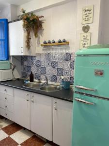 a kitchen with a blue refrigerator and a sink at La Casita del Albayzín in Granada