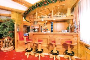 a kitchen with a bar with stools in front of it at Hotel Diamant Park in Campitello di Fassa