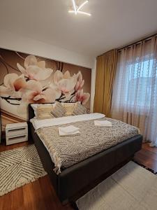 a bedroom with a bed with a flower mural on the wall at Alinaalis in Zărneşti