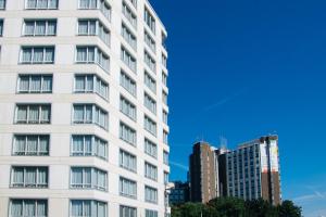 a tall white building in front of some buildings at The Originals Résidence Paris Sud Villejuif in Villejuif