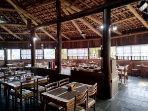 a restaurant with wooden tables and chairs and windows at VELINN Hotel Fazenda Estrela da Serra in Santo Antônio do Pinhal