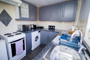 a kitchen with a sink and a washing machine at Church Street House in Canterbury