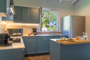 - une cuisine avec des armoires bleues et un réfrigérateur bleu dans l'établissement Villa Cammà with private pool, à Mirto