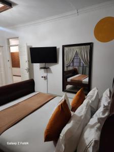a bedroom with a large bed and a mirror at Sunshine Inn in Gaborone