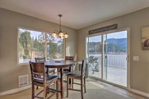 ein Esszimmer mit Tisch und Stühlen und einem großen Fenster in der Unterkunft Lake Loon Hillside Cottage with Private Deck! in Loon Lake