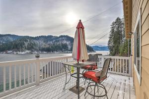 ein Tisch mit einem Sonnenschirm und zwei Stühlen auf einem Balkon in der Unterkunft Lake Loon Hillside Cottage with Private Deck! in Loon Lake