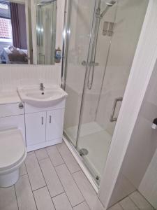 a bathroom with a shower and a toilet and a sink at THE COASTAL INN ACCOMMODATIONs in Cellardyke