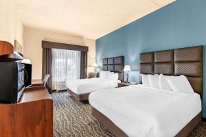 a hotel room with two beds and a flat screen tv at Best Western Holiday Manor in Newton +24 photos