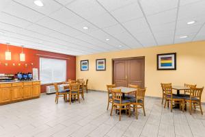 a waiting room with tables and chairs in a cafeteria at Best Western Holiday Manor in Newton